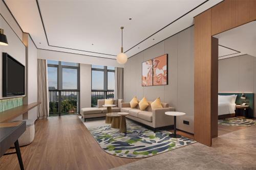 a living room with a couch and a tv at Hilton Garden Inn Guiyang Gui'An New Area in Guiyang