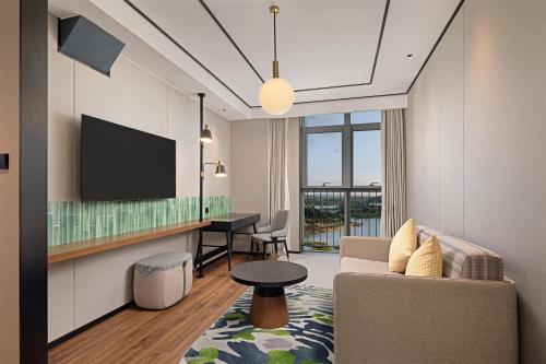 a living room with a couch and a tv at Hilton Garden Inn Guiyang Gui'An New Area in Guiyang