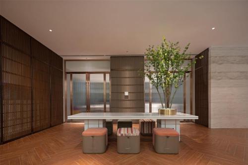 a dining room with a table and two stools at Hilton Garden Inn Guiyang Gui'An New Area in Guiyang