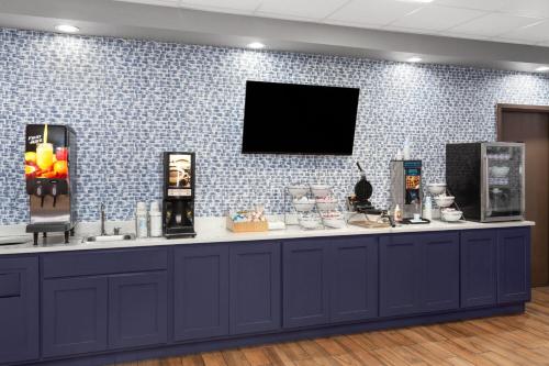 a blue and white counter with a tv on a wall at AmericInn & Suites by Wyndham Baraboo Event Center in Baraboo