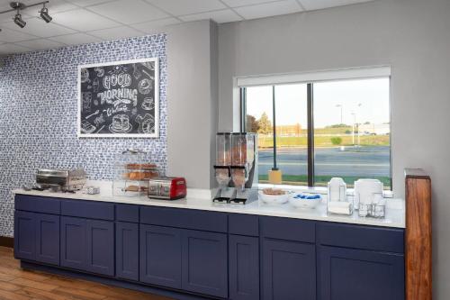 a kitchen with a counter top with a window at AmericInn & Suites by Wyndham Baraboo Event Center in Baraboo