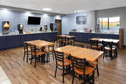 a restaurant with wooden tables and a bar at AmericInn & Suites by Wyndham Baraboo Event Center in Baraboo