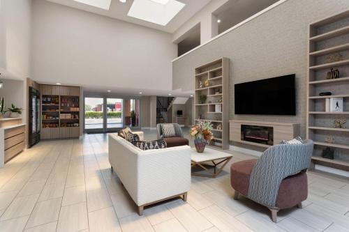 a living room with a couch and chairs and a tv at Hawthorn Extended Stay by Wyndham Ft Lauderdale Cypress Crk in Fort Lauderdale