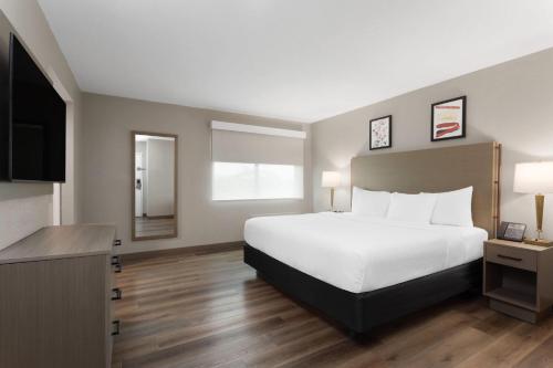 a hotel room with a bed and a television at Hawthorn Extended Stay by Wyndham Ft Lauderdale Cypress Crk in Fort Lauderdale