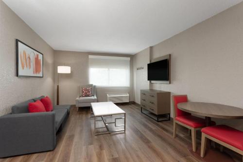 a living room with a couch and a table at Hawthorn Extended Stay by Wyndham Ft Lauderdale Cypress Crk in Fort Lauderdale