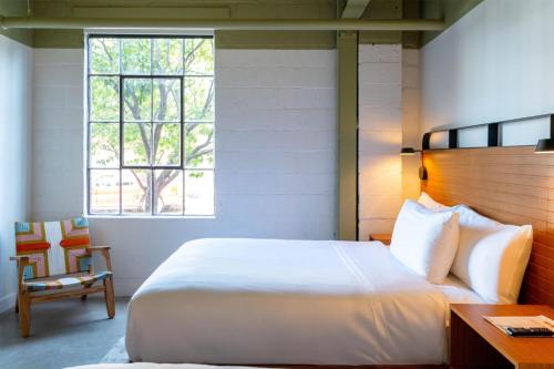 a bedroom with a bed and a desk and a window at The Myriad Hotel Louisville, Tapestry Collection by Hilton in Louisville