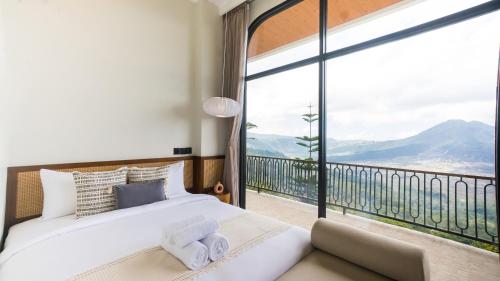 a bedroom with a bed and a large window at El Lago Hotel in Kintamani