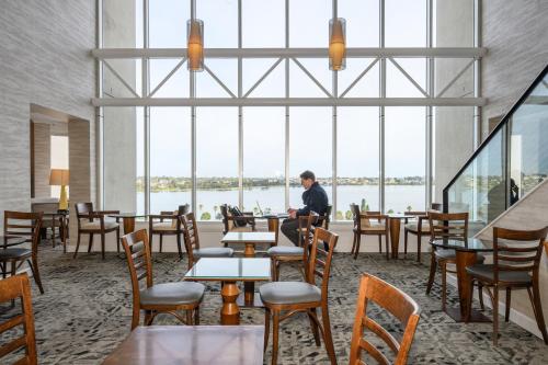 a man sitting at a table in a restaurant with windows at Residence on Langley Park in Perth