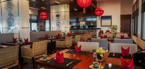 a restaurant with tables and chairs and red lamps at The Blue Water - Geoffrey Bawa Heritage Resort Hotel in Wadduwa