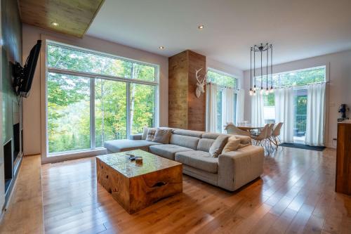 a living room with a couch and a table at Spa River and Comfort - Domaine de la Seigneurie in Sainte Béatrix