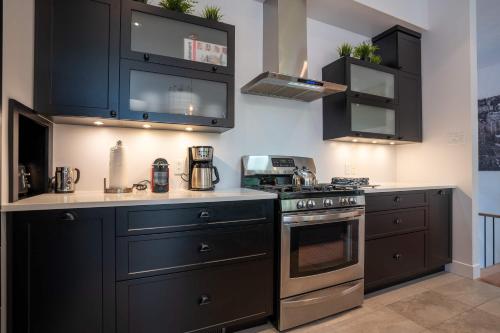 a kitchen with black cabinets and a stove at Spa River and Comfort - Domaine de la Seigneurie in Sainte Béatrix