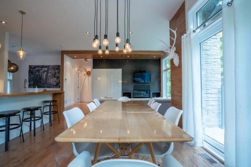 a dining room and kitchen with a wooden table and chairs at Spa River and Comfort - Domaine de la Seigneurie in Sainte Béatrix