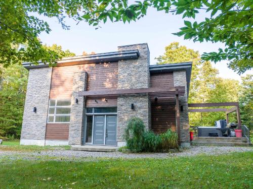 a brick house with a garage at Spa River and Comfort - Domaine de la Seigneurie in Sainte Béatrix