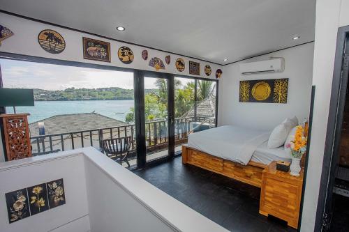 a bedroom with a bed and a balcony with a view at Indigo Blue Ceningan in Nusa Lembongan