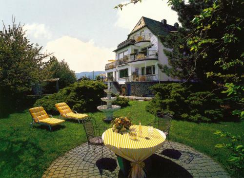 a house with a table and chairs and a fountain at Haus Marientaler Au GbR in Zell an der Mosel