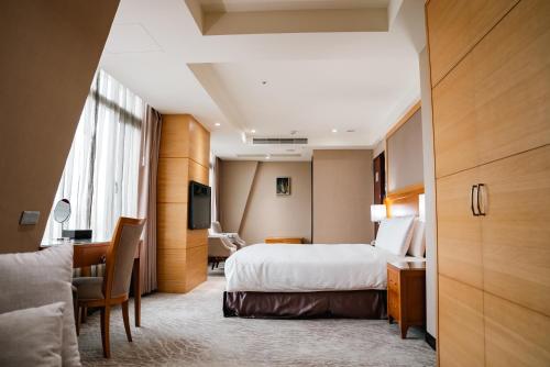 a hotel room with a bed and a desk at Arsma Hotel in Hualien City