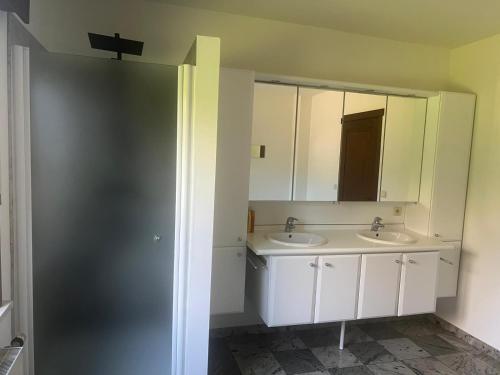 a bathroom with two sinks and a mirror at Villa op de hoek Rooms in Aalst