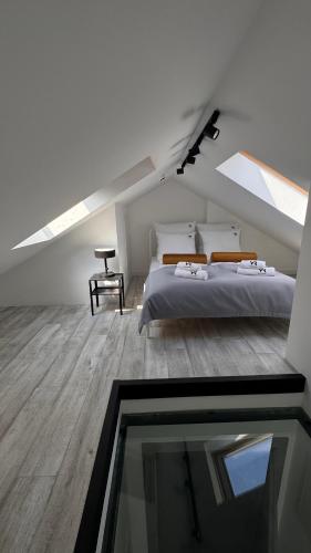 a attic bedroom with a bed and a glass window at Villa Rasmus in Kołobrzeg