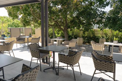 an outdoor seating area with tables and chairs at Kracher Hotel Doppelzimmer - für maximal 4 Personen inklusive Pool in Illmitz