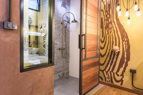 a bathroom with a shower and a glass door at Sea Crest by Jomtien in Jomtien Beach