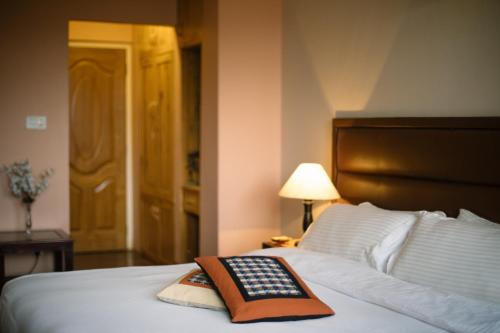 a remote control sitting on top of a bed at Tajaa Pha The Heritage Home in Pātan