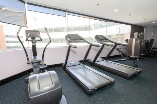 a gym with three cardio machines in front of a window at Residence on Langley Park in Perth