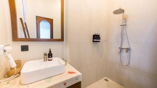 a white bathroom with a sink and a shower at El Lago Hotel in Kintamani