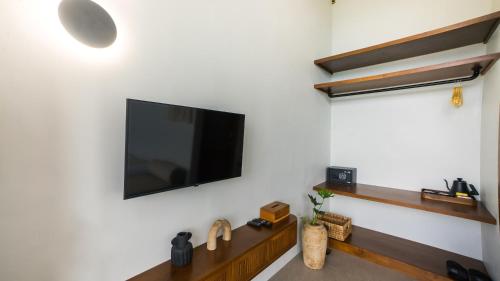 a living room with a flat screen tv on a wall at El Lago Hotel in Kintamani