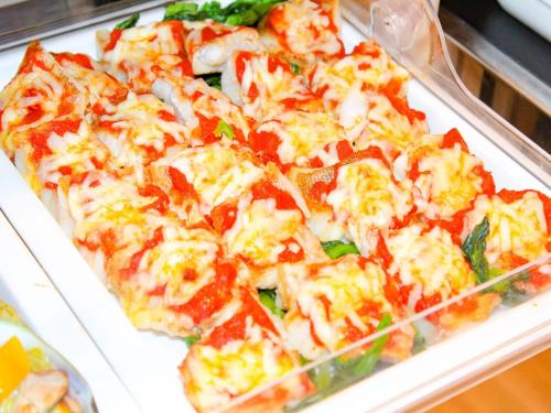 a pizza sitting on top of a white plate at THE GRAND HOTEL GINOWAN in Ginowan