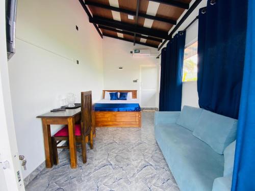 a room with a couch and a bed and a table at TK Homes in Badulla