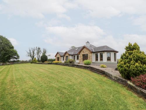 a house on a hill with a large yard at Swan Lake in Boyle