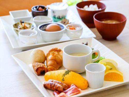 two white plates of food with cups of tea and pastries at THE GRAND HOTEL GINOWAN in Ginowan