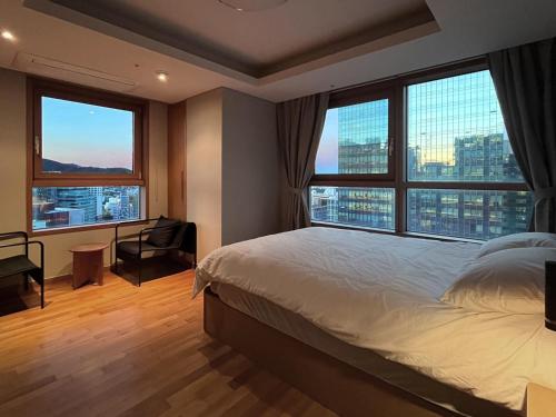a bedroom with a large bed and large windows at Gyeongbokgung Palace View, 3-min Walk to Gwanghwamun & Jonggak Stations in Seoul