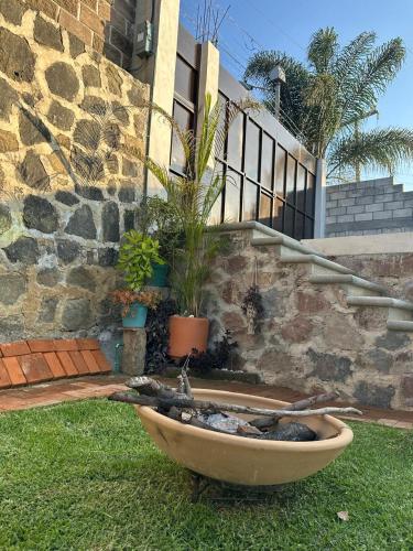 a bath tub sitting in the grass in front of a house at Casa Palmer, con gran jardín in Totolapan