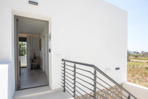 a staircase in a white house with a balcony at Nostos Luxury Apartments in Kremasti