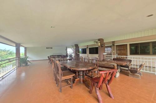 a dining room with a wooden table and chairs at Phaiboon Hotel & Resort in Pak Chong