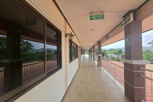 an empty hallway of a building with windows at Phaiboon Hotel & Resort in Pak Chong