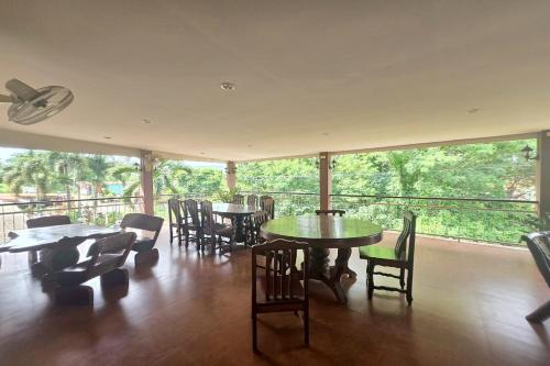 a restaurant with tables and chairs and a large window at Phaiboon Hotel & Resort in Pak Chong
