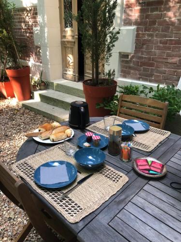 een houten tafel met blauwe platen en eten erop bij Château de la Françoisière in Luceau