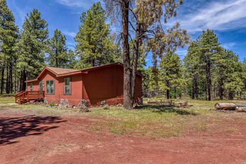 a small red house in the middle of a forest at Gorgeous Historic 3 BR Log Cabin w Forest Views 20 Minutes from Flagstaff Now with Wi-Fi in Parks