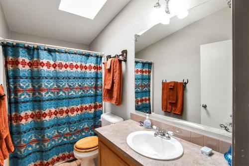 a bathroom with a blue shower curtain and a sink at Gorgeous Historic 3 BR Log Cabin w Forest Views 20 Minutes from Flagstaff Now with Wi-Fi in Parks