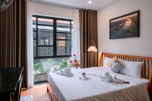 a bedroom with a bed with towels on it at Du Yen Hoi An Villa in Hoi An