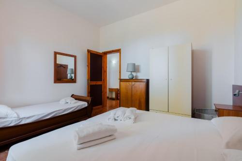 two beds in a room with white sheets and towels at Villa Santa Anastasia in Matino