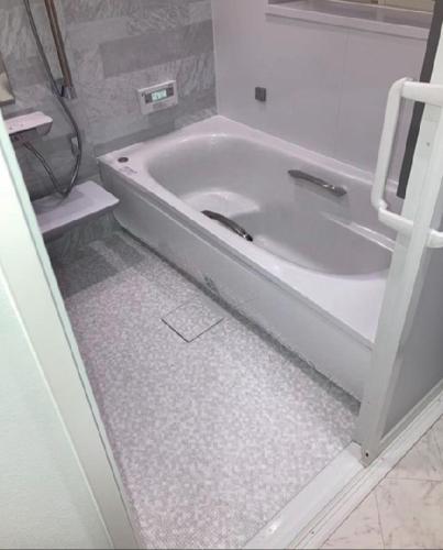 a white bath tub sitting in a bathroom at 福のや in Unnan