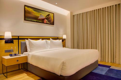a hotel room with a large bed with white pillows at Cygnett Inn in Dibrugarh