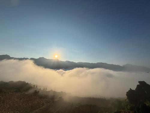 a view of the sun rising over a foggy valley at Homestay Trúc Sơn in Hong Ha