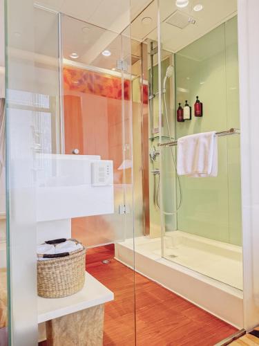 a bathroom with a glass shower with a sink at Stanford Hillview Hotel Hong Kong in Hong Kong