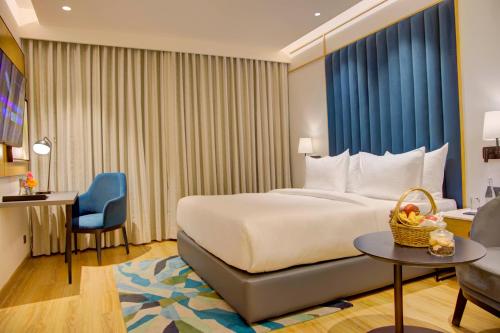 a hotel room with a bed and a chair at Cygnett Inn in Dibrugarh