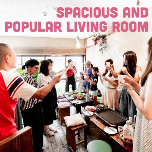 a group of people standing around a table eating food at LovesunshineBackpackers in Tokyo