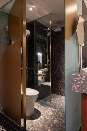 a bathroom with a toilet and a glass door at Bintang Collectionz Hotel in Kuala Lumpur